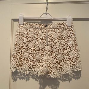 Alice and Olivia nude and white lace shorts.